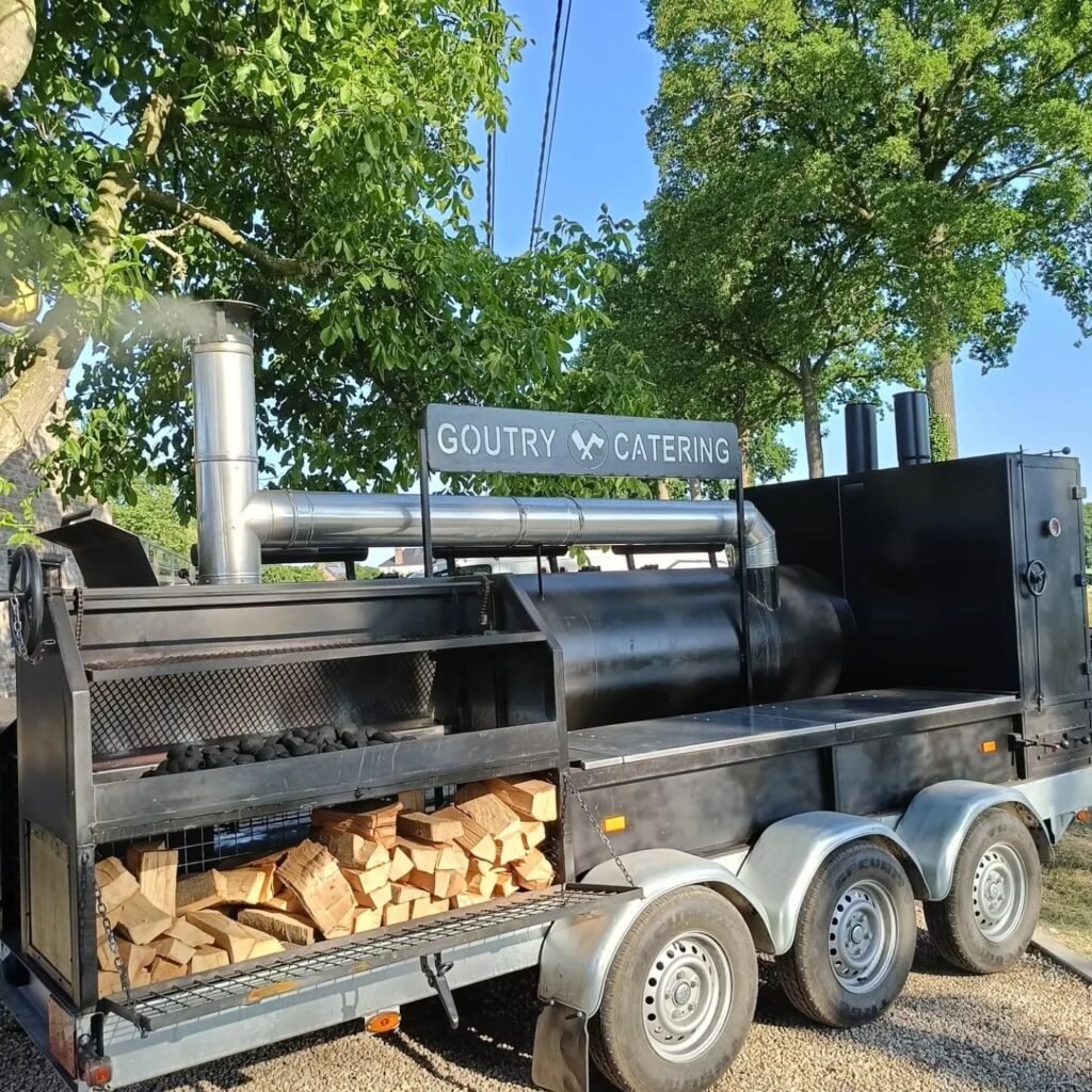 Professionele BBQ-smoker op aanhanger van Goutry Catering met houtblokken bij Feestlocatie Alegria